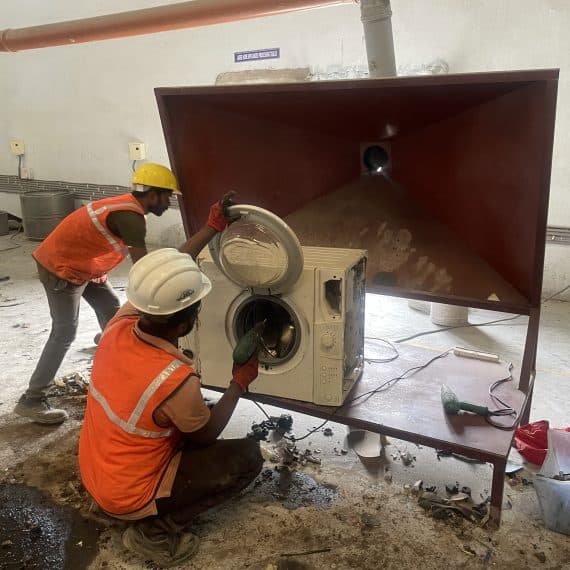 Workers processing electronics in refurbishment facility